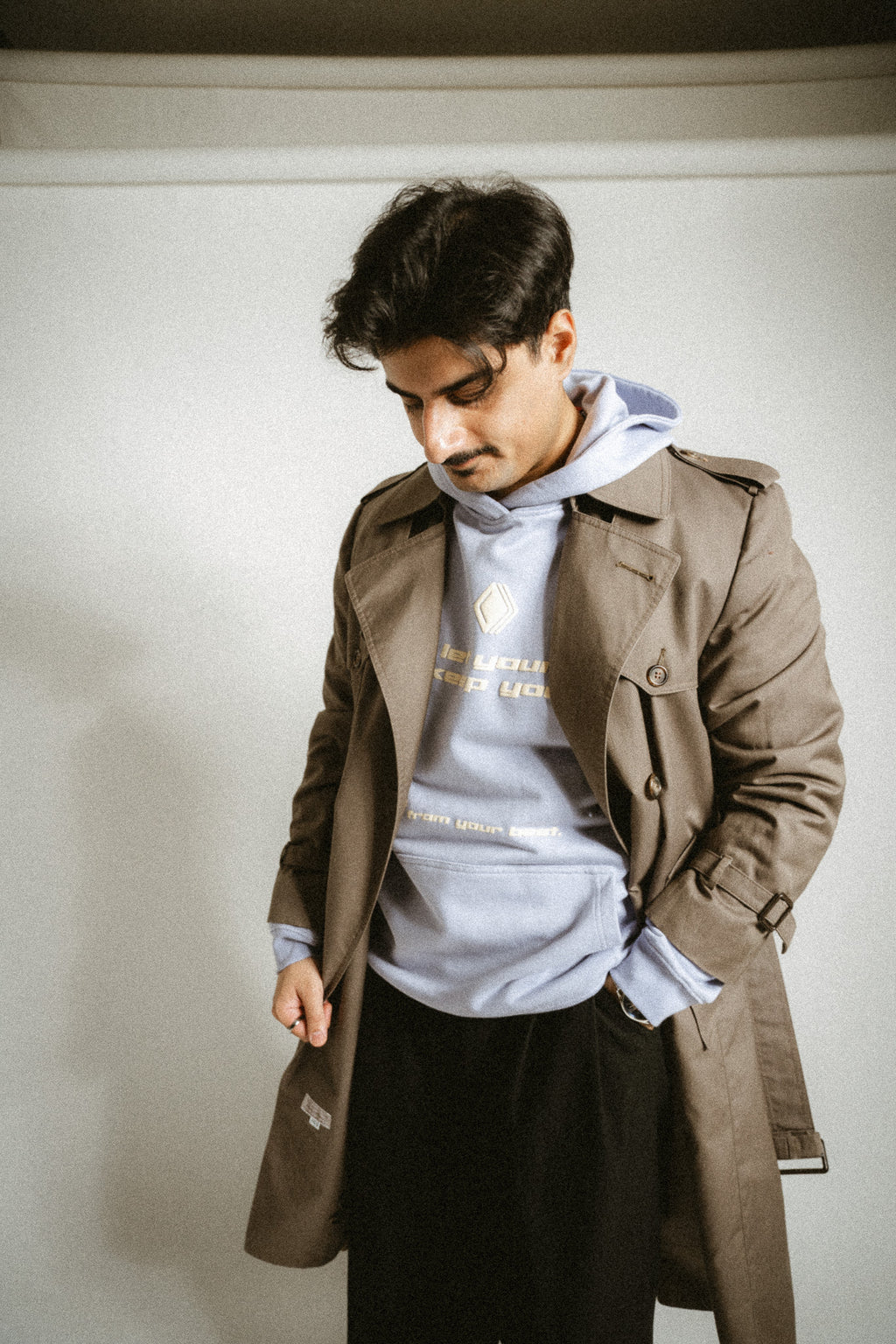 Person trägt unter einem Mantel einen hellblauen Unisex-Hoodie mit dem Markenlogo 'BAKLAVA' auf der Brust. Der Hoodie hat eine Drop-Shoulder-Passform, ist leicht oversized und besteht aus schwerer French Terry Baumwolle für Langlebigkeit und Komfort. Der Schriftzug auf dem Hoodie lautet 'don't let your past keep you' in größerer Schrift, mit 'from your best' in kleinerer Schrift darunter. Inspiriert von Kendrick Lamar’s Song 'Die Hard'.