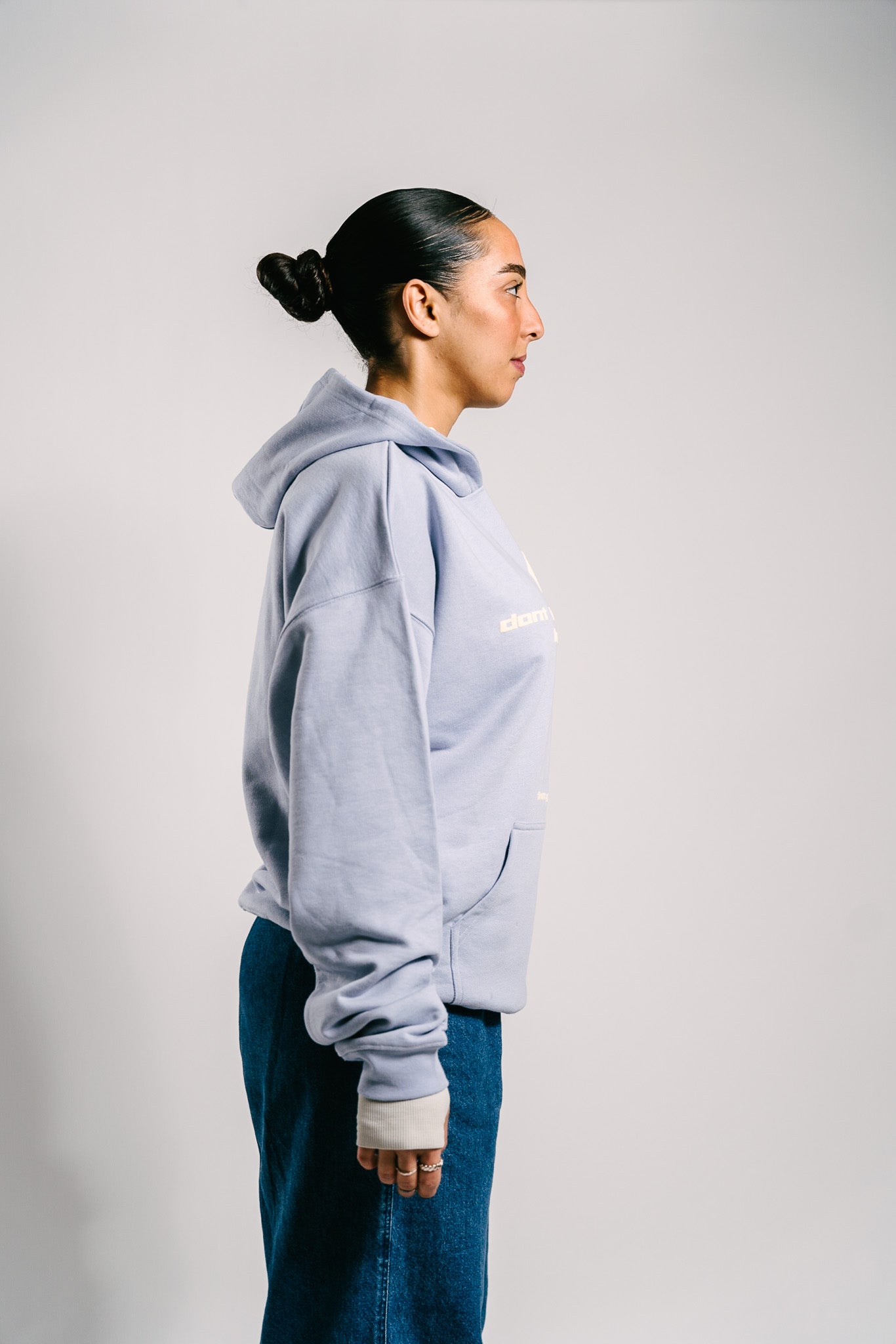 Person trägt einen hellblauen Unisex-Hoodie mit dem Markenlogo 'BAKLAVA' auf der Brust. Der Hoodie hat eine Drop-Shoulder-Passform, ist leicht oversized und besteht aus schwerer French Terry Baumwolle für Langlebigkeit und Komfort. Der Schriftzug auf dem Hoodie lautet 'don't let your past keep you' in größerer Schrift, mit 'from your best' in kleinerer Schrift darunter. Inspiriert von Kendrick Lamar’s Song 'Die Hard'.